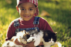 Boy Wearing Overalls Holding Kittens